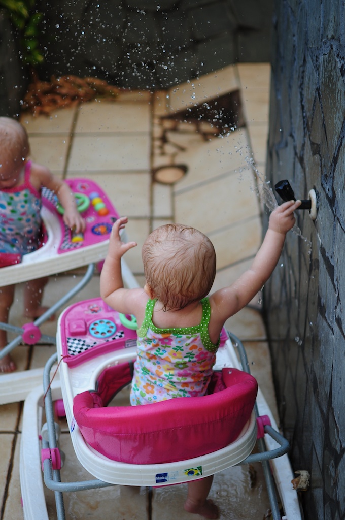 Becca has learned how to turn on the spicket and spray Anna. Becca has learned how to turn on the spicket and spray Anna.